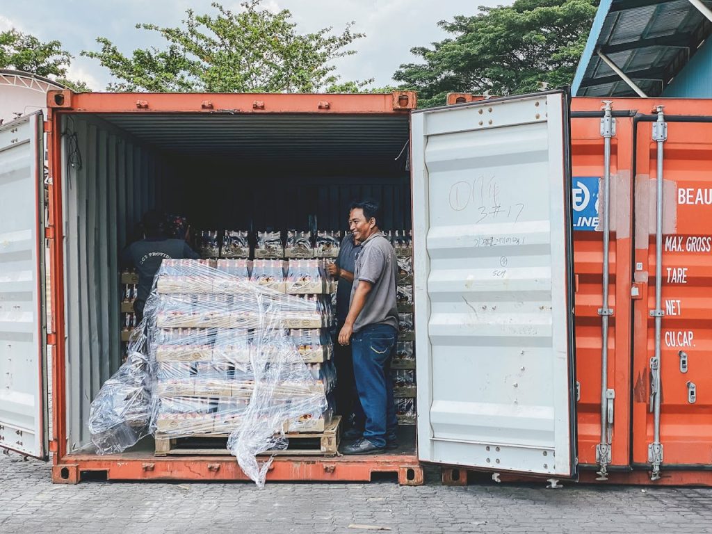 pexels photo 18874291 Two men load products into a shipping container in Ipoh, Malaysia, showcasing logistics.