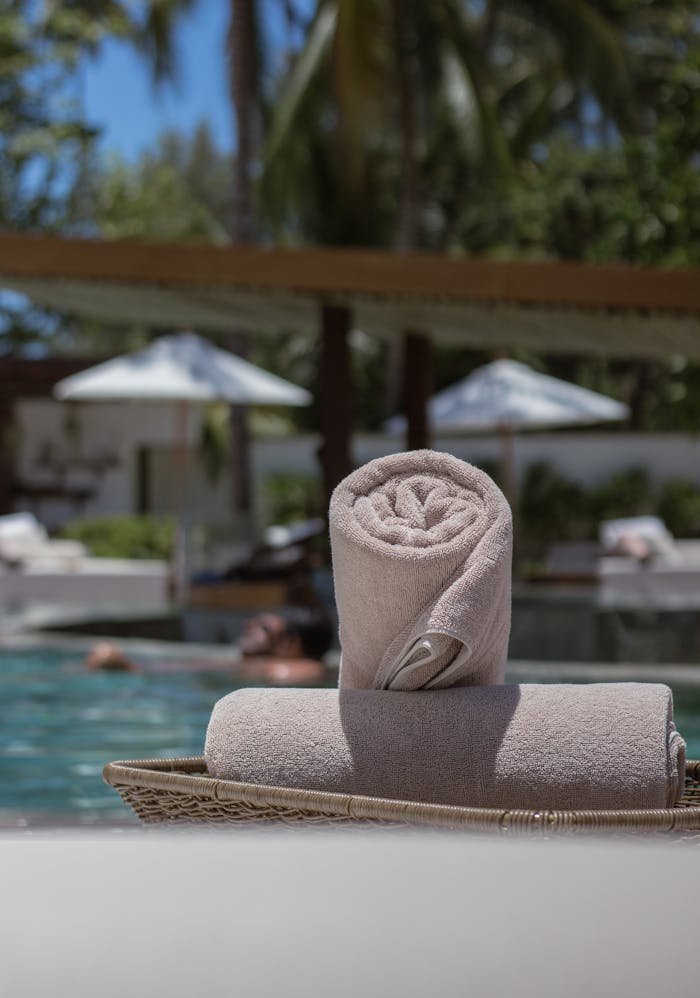 Tropical poolside ambiance with sunshades and fresh towels ready for a perfect summer day.