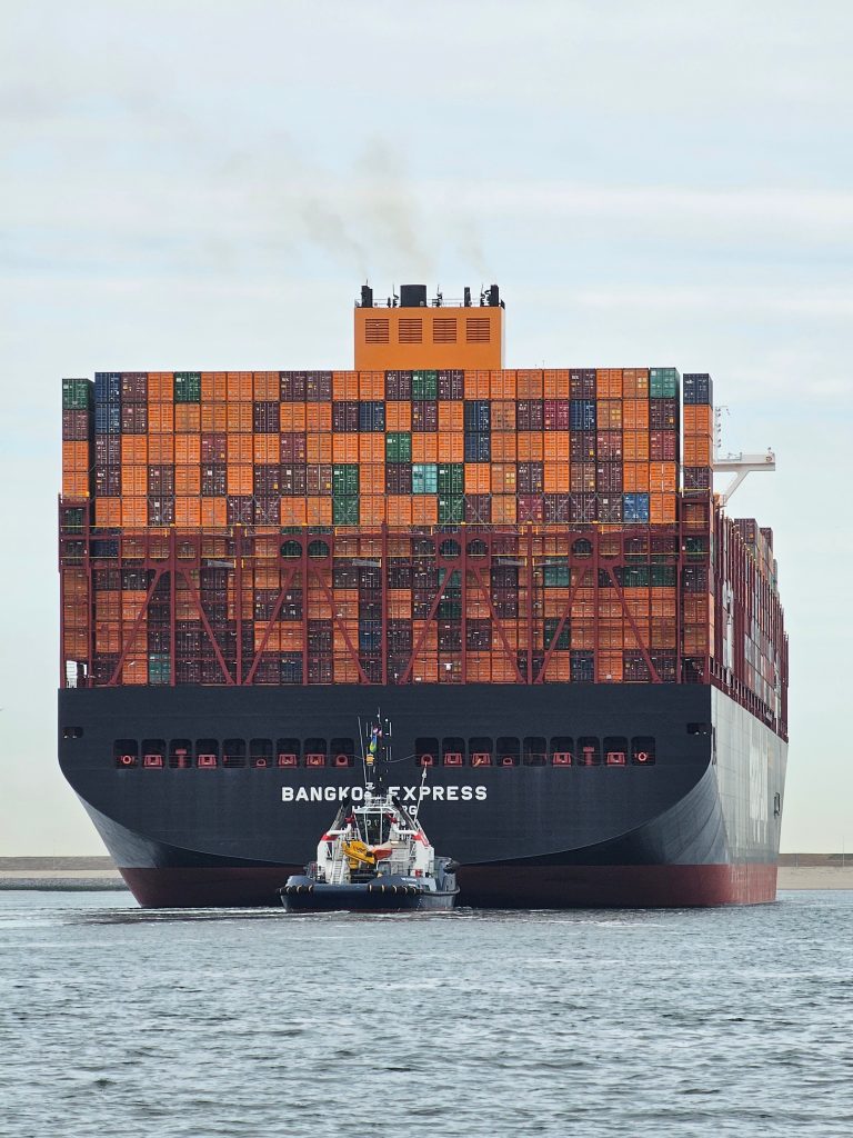 pexels photo 31688186 31688186 Large container ship 'Bangkok Express' with tugboat at Maasvlakte Rotterdam.
