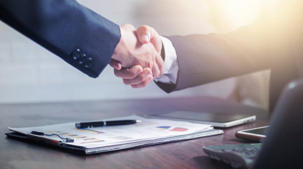 pexels photo 4175028 Professional handshake agreement over business charts in an office setting.